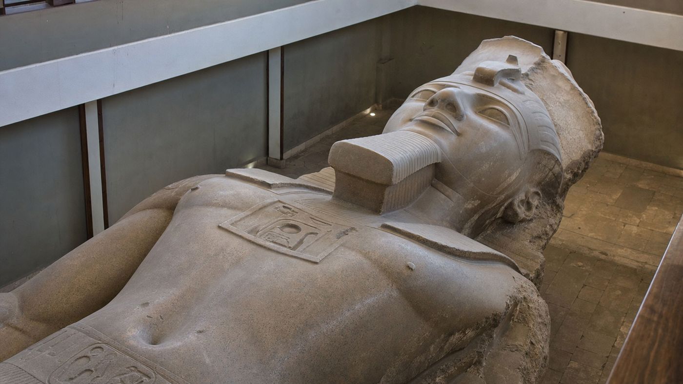 The recumbent colossus of Ramses II in the hall of Memphis, seen from a walkway