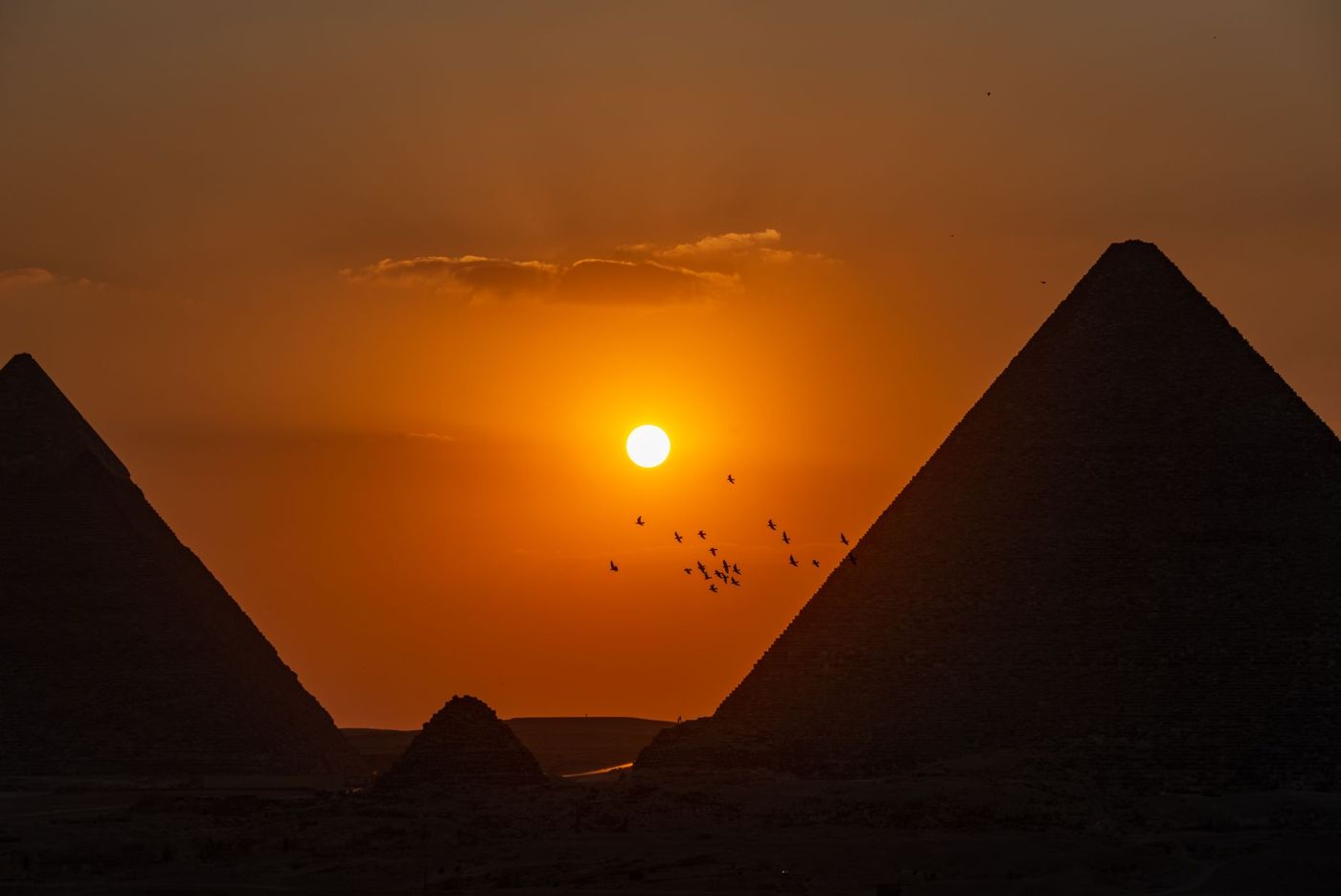 Pyramids as dark silhouettes against the evening sky, taken from the west