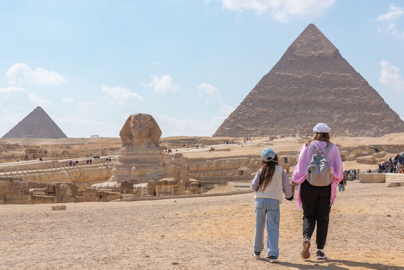 Famiglie egiziane con coperte da picnic su un'area aperta davanti a una piramide