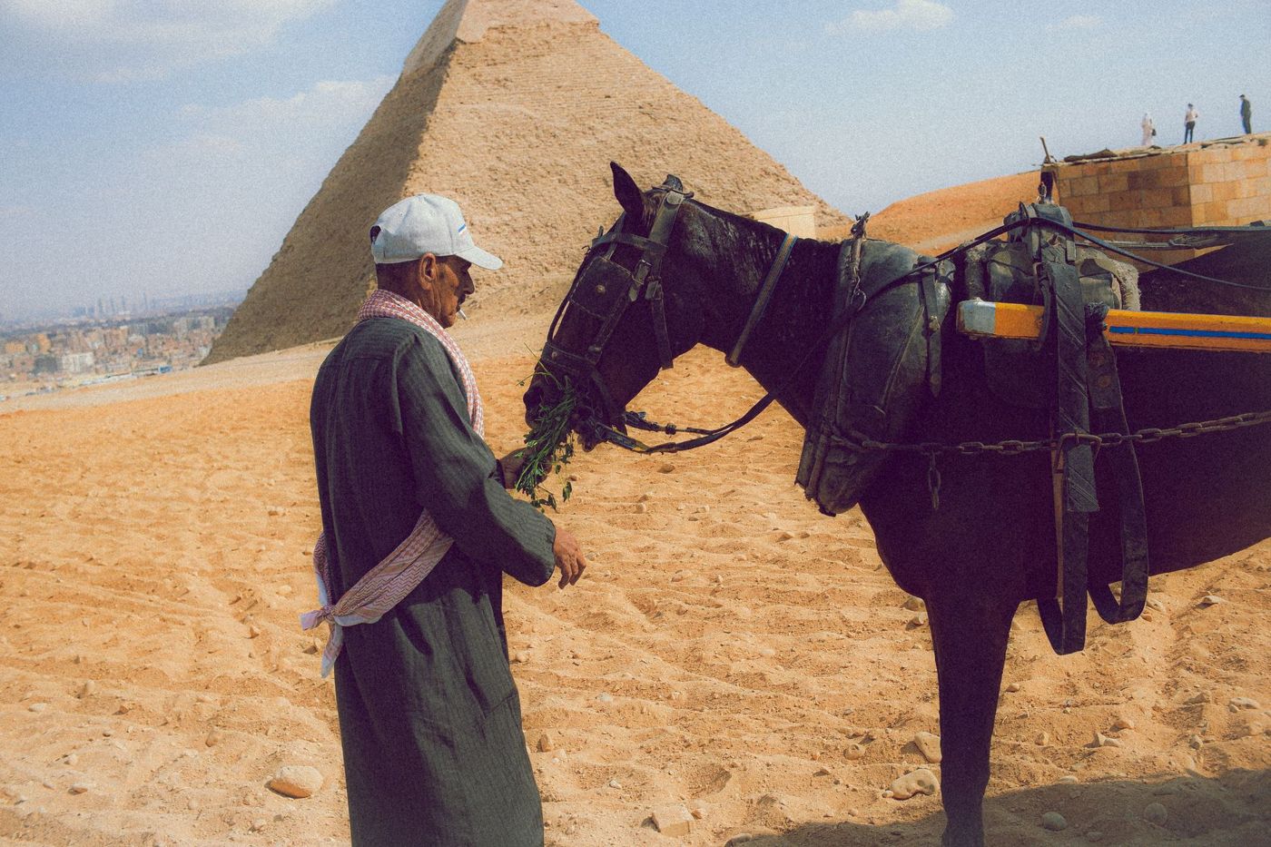 Tourismuspolizist am Rand des Geländes, im Hintergrund Besucher und eine Pyramide