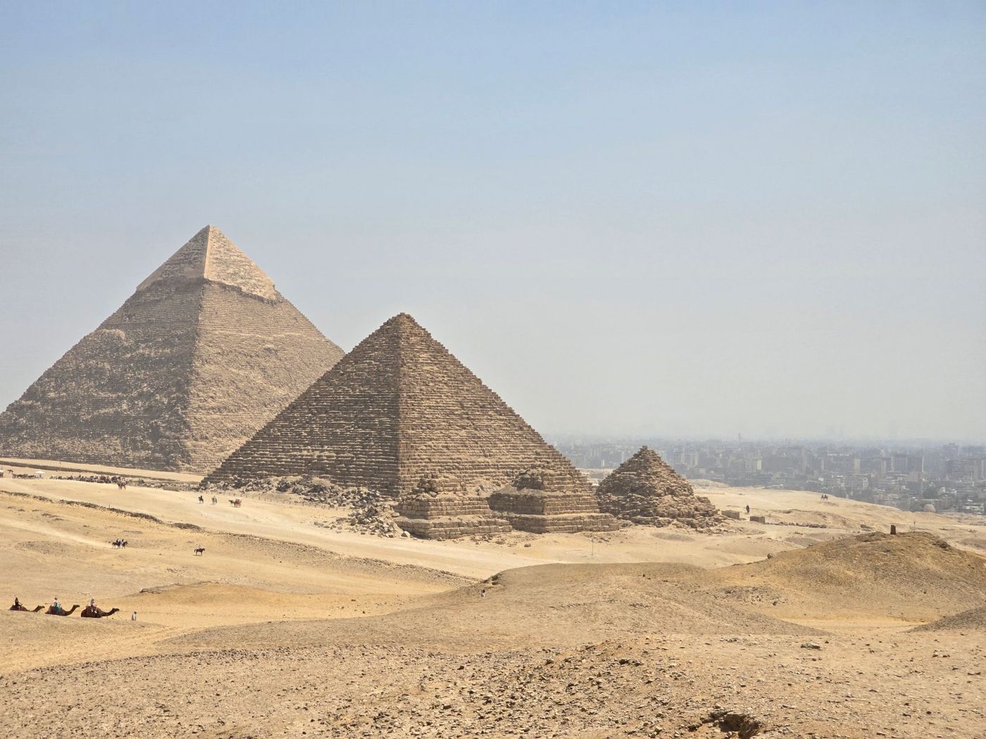 View over the plateau with the three pyramids and the city in the background
