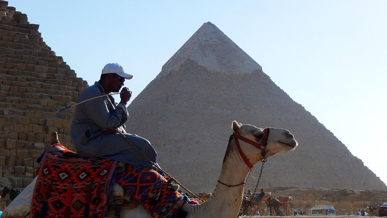 Guida con gruppo davanti a una piramide, in conversazione piuttosto che in conferenza