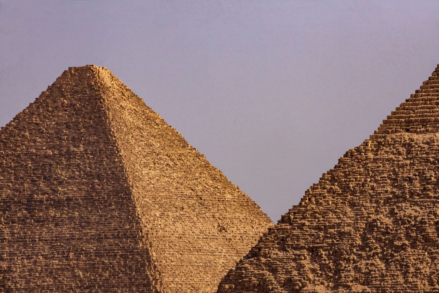 Personne seule au pied d'un flanc de pyramide, les blocs la dépassent nettement