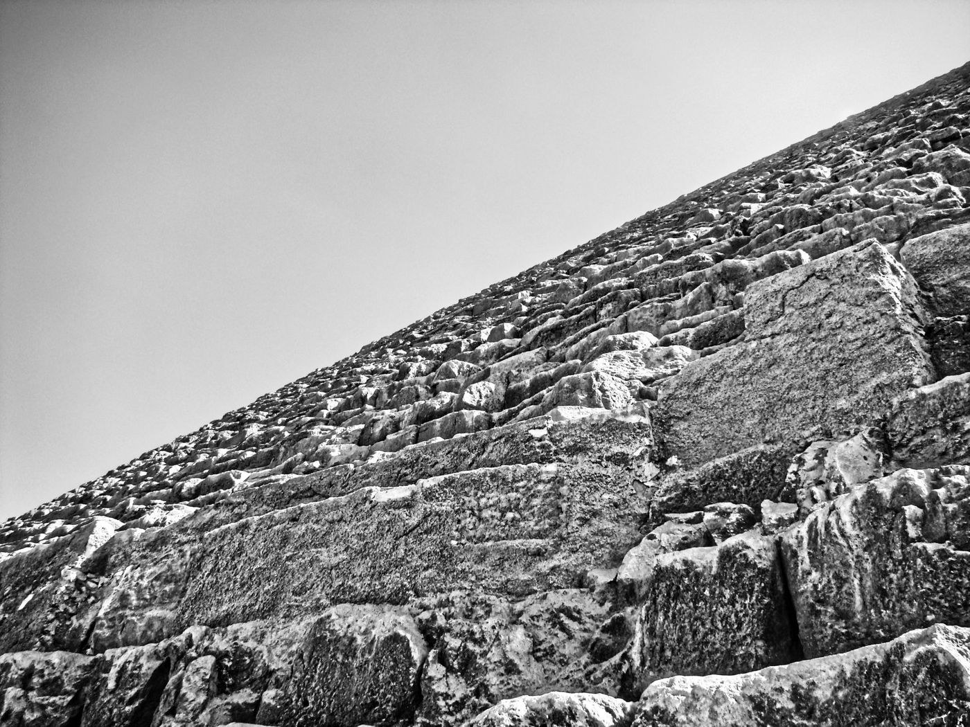 Niño frente a los grandes bloques de piedra en la base de una pirámide