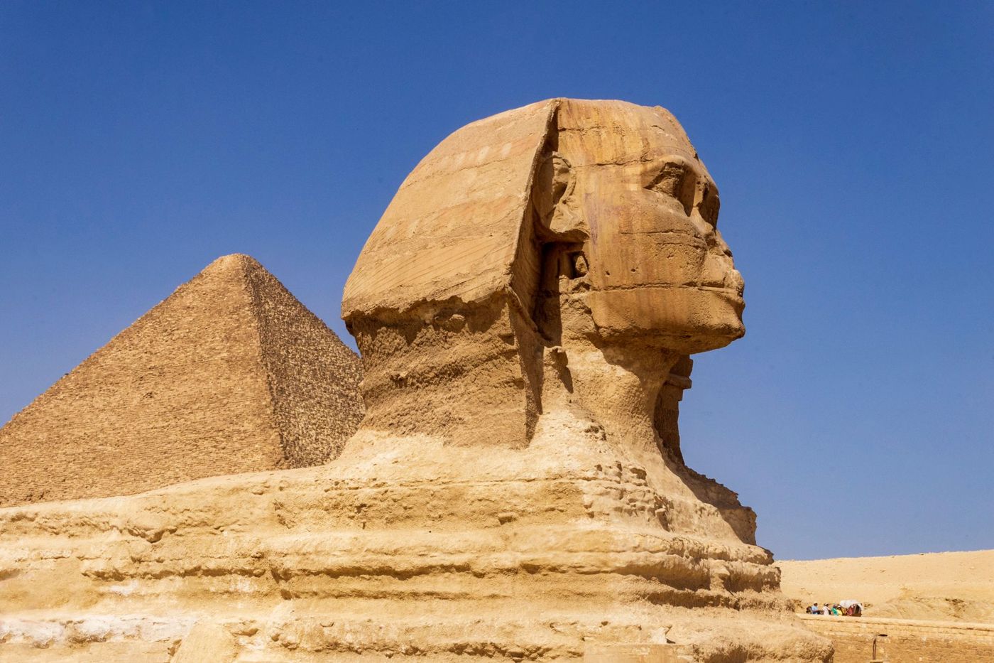 Small tour group with guide in front of the Sphinx in the early morning